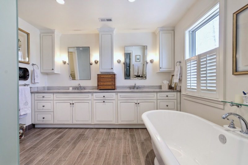 white-bathroom-with-custom-wood-flooring-white-freestanding-bathtub