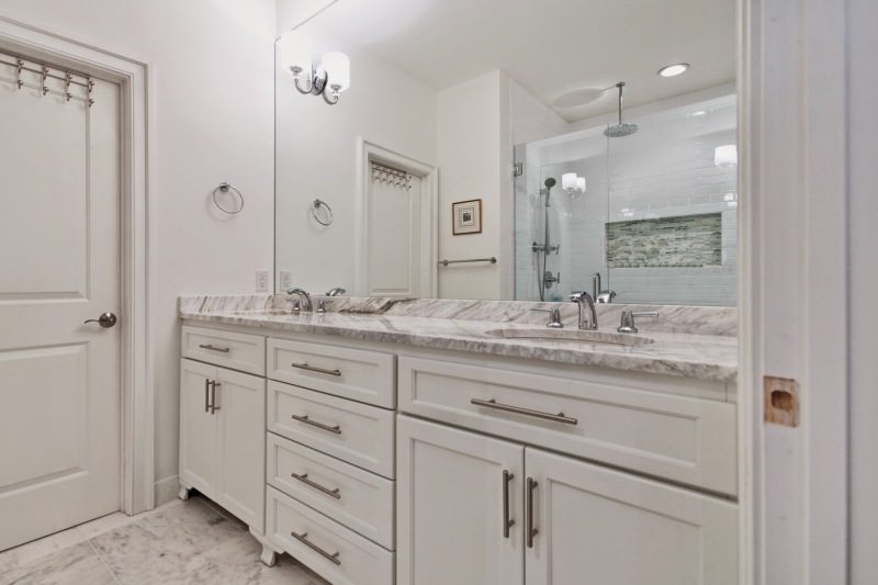 white-bathroom-with-wood-base-metal-accents-double-sink