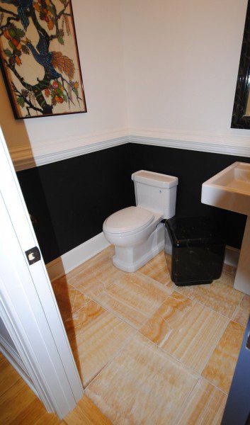 white-toilet-sitting-on-custom-tiled-light-brown-floor