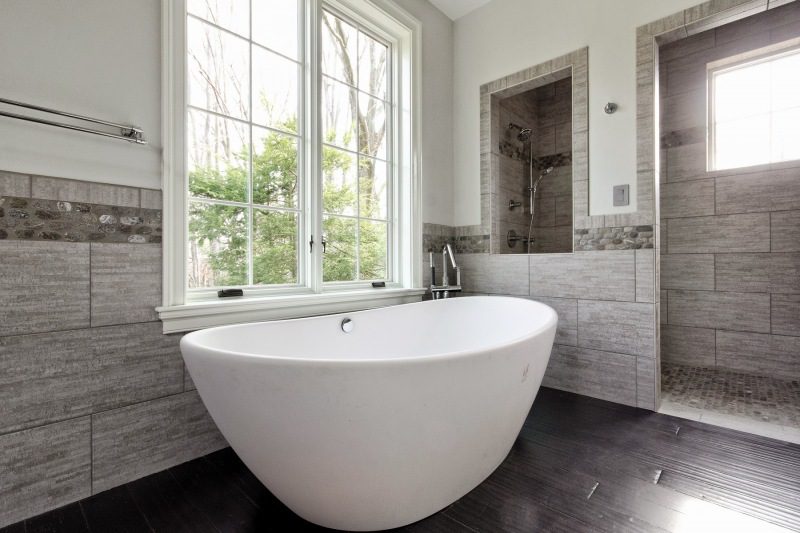 Gray Stone Bathroom With Freestanding White Tub