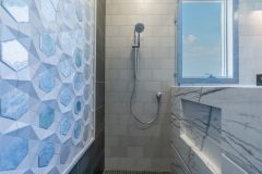 walk-in-shower-with-blue-tile-and-adjustable-shower-head